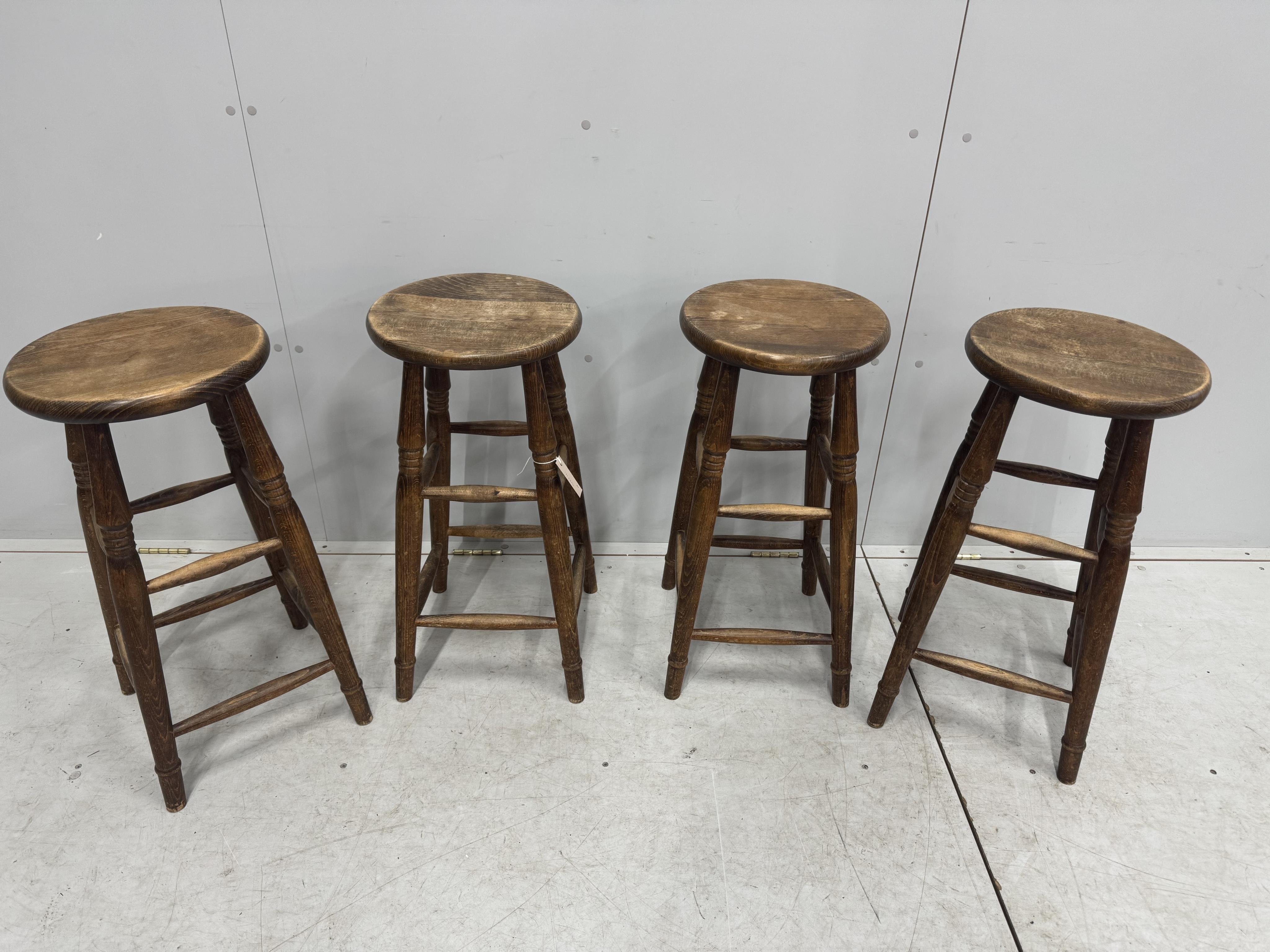 A set of four vintage beech bar stools, diameter 33cm, height 69cm. Condition - fair